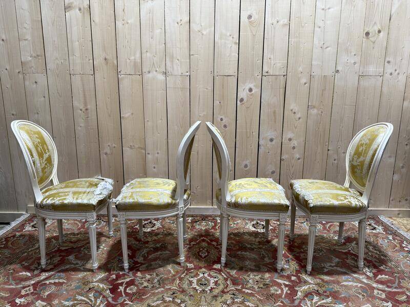 Suite de 4 chaises médaillons de style Louis XVI rechampi blanc cassé
