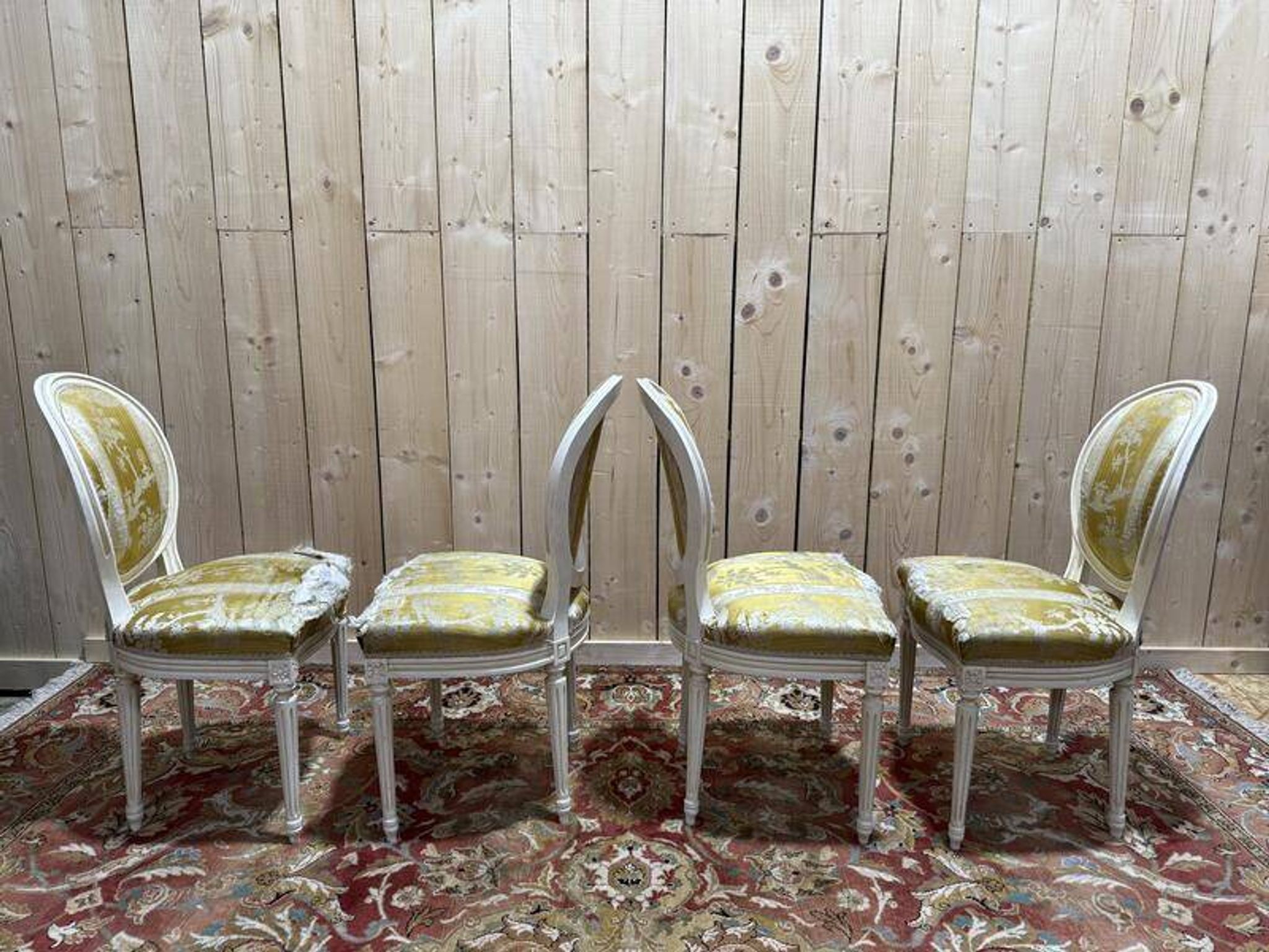 Suite de 4 chaises médaillons de style Louis XVI rechampi blanc cassé