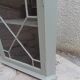 Vintage English corner display cabinet enhanced in grey-green with a wooden top.