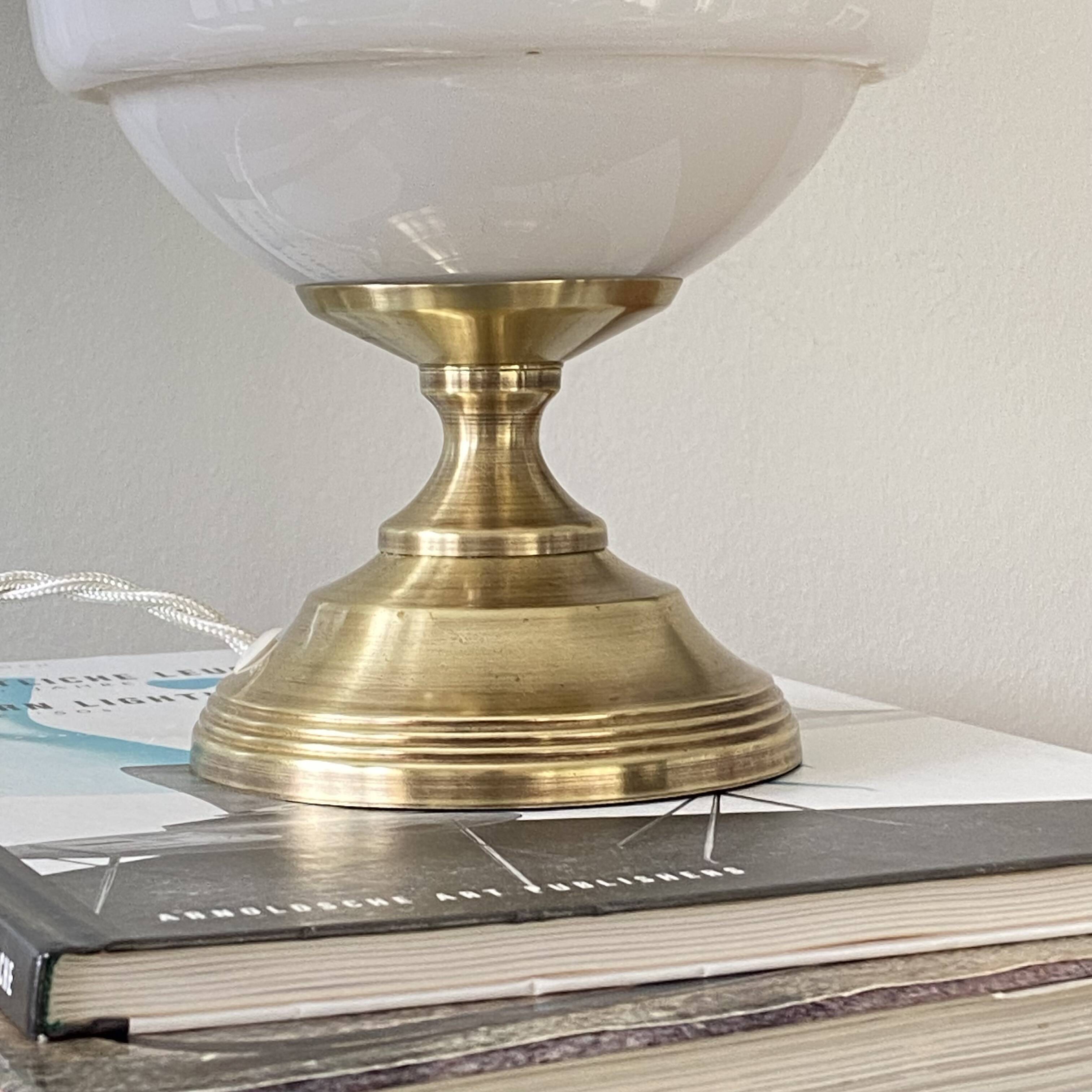 Antique white opaline glass globe table lamp with a brass base.