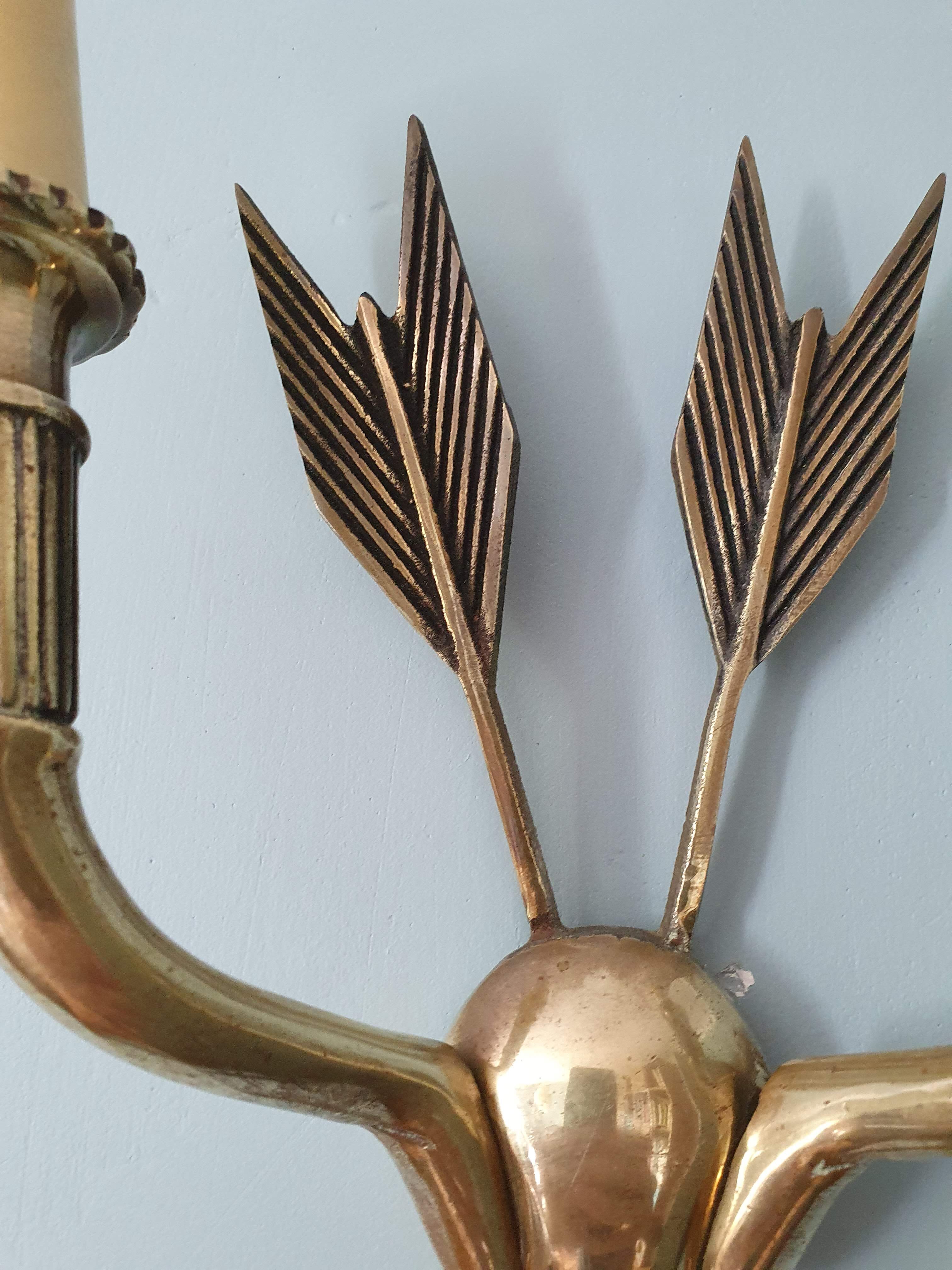Vintage wall lamp decorated with bronze arrows