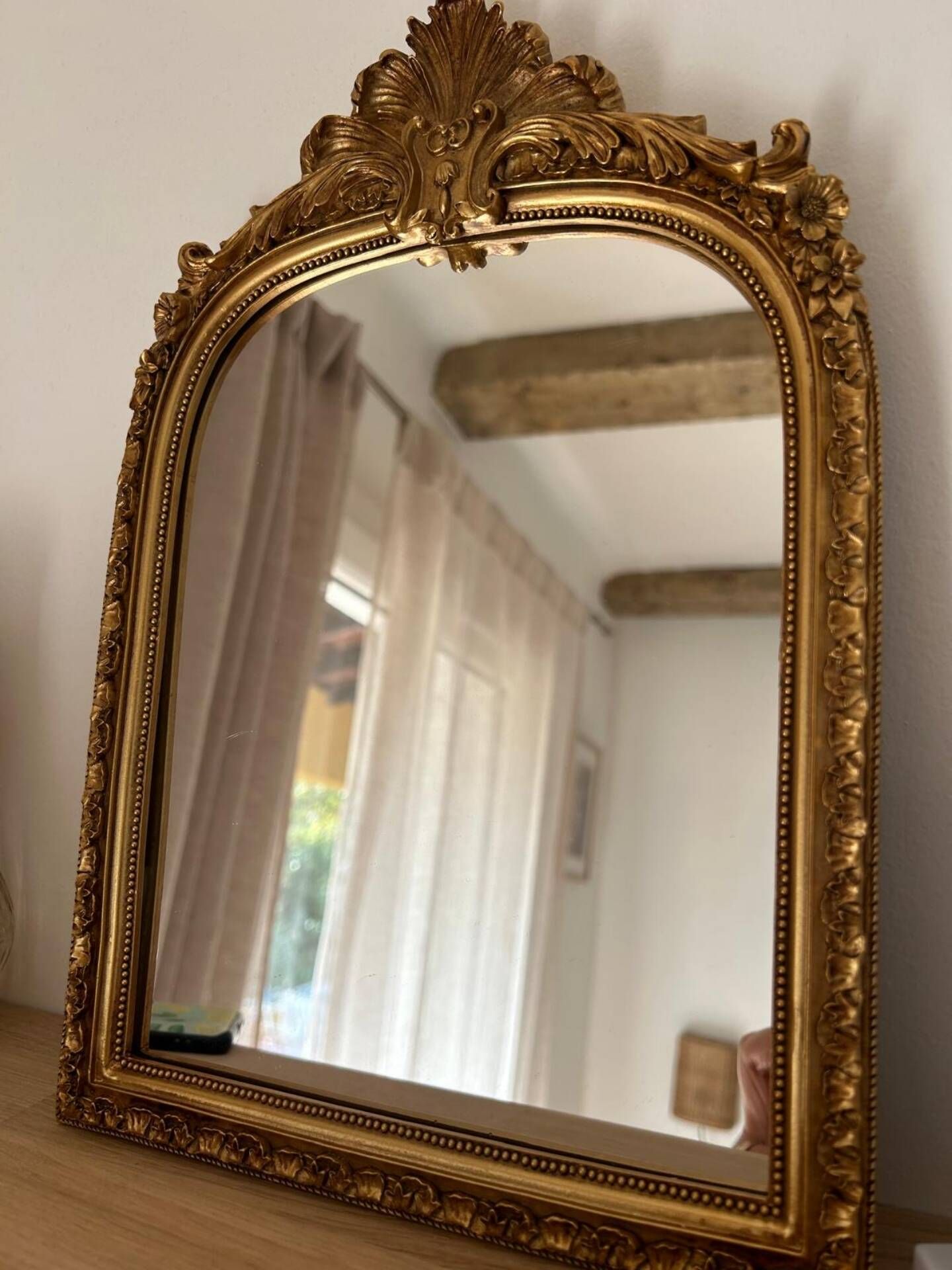 Miroir décoratif avec moulures et fronton.