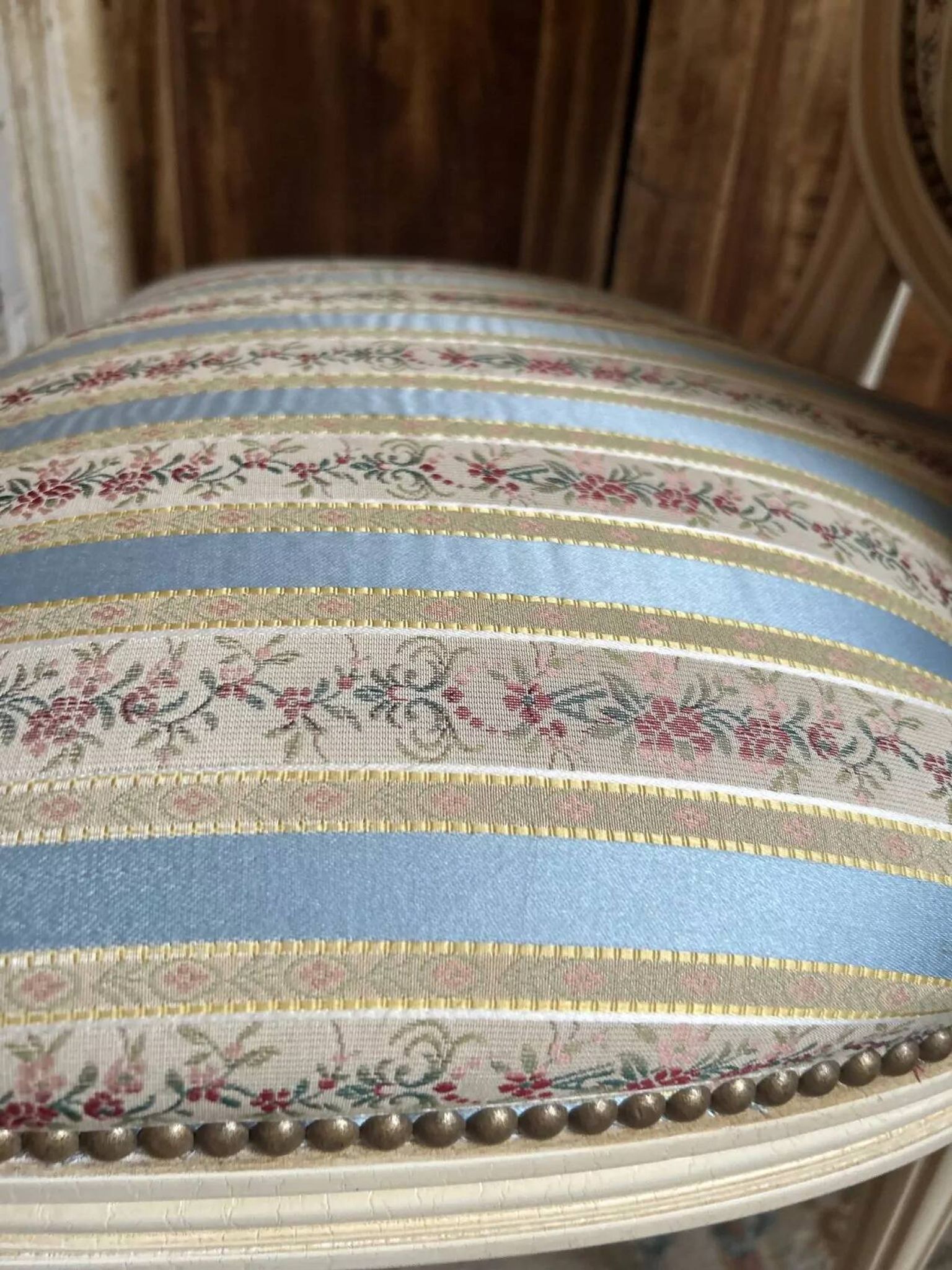 Pair of Louis XVI style chairs in painted wood and satin, classic elegance.