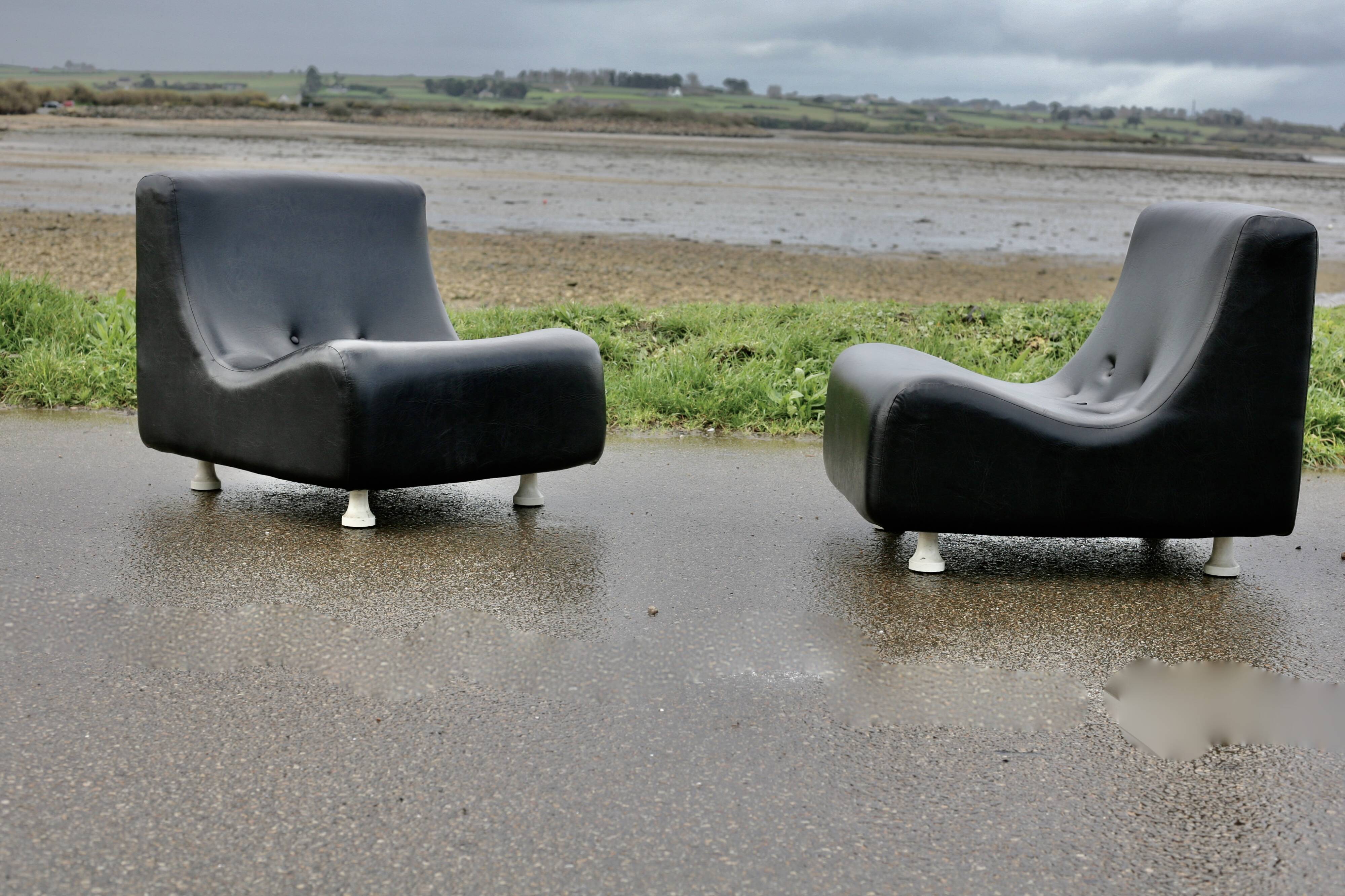 Pair of “space age” low chairs. Black faux leather. Circa 1970