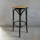 Curved wooden bar stool with a caned seat.