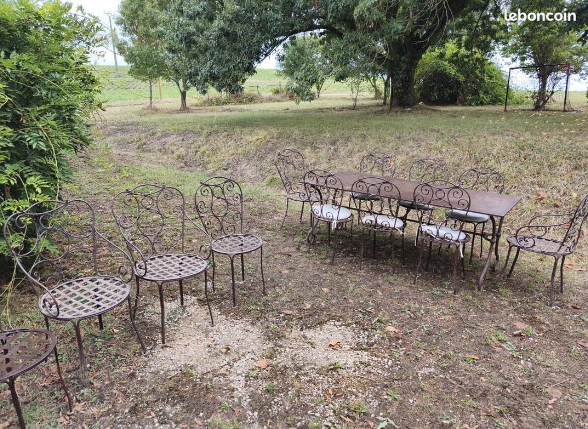 Old wrought iron table and its armchairs and chairs for outdoor use.