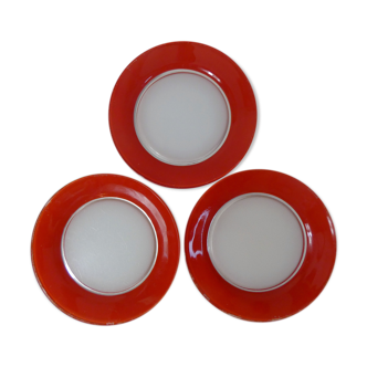 3 assiettes plates, de couleur rouge Duralex.