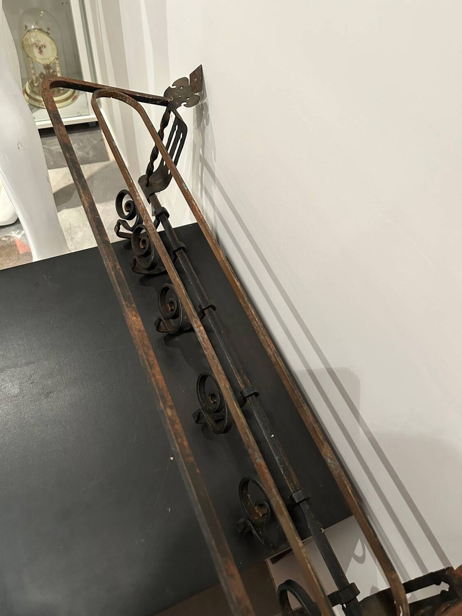 Large antique wall-mounted coat rack in wrought iron.