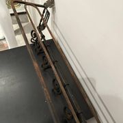 Large antique wall-mounted coat rack in wrought iron.