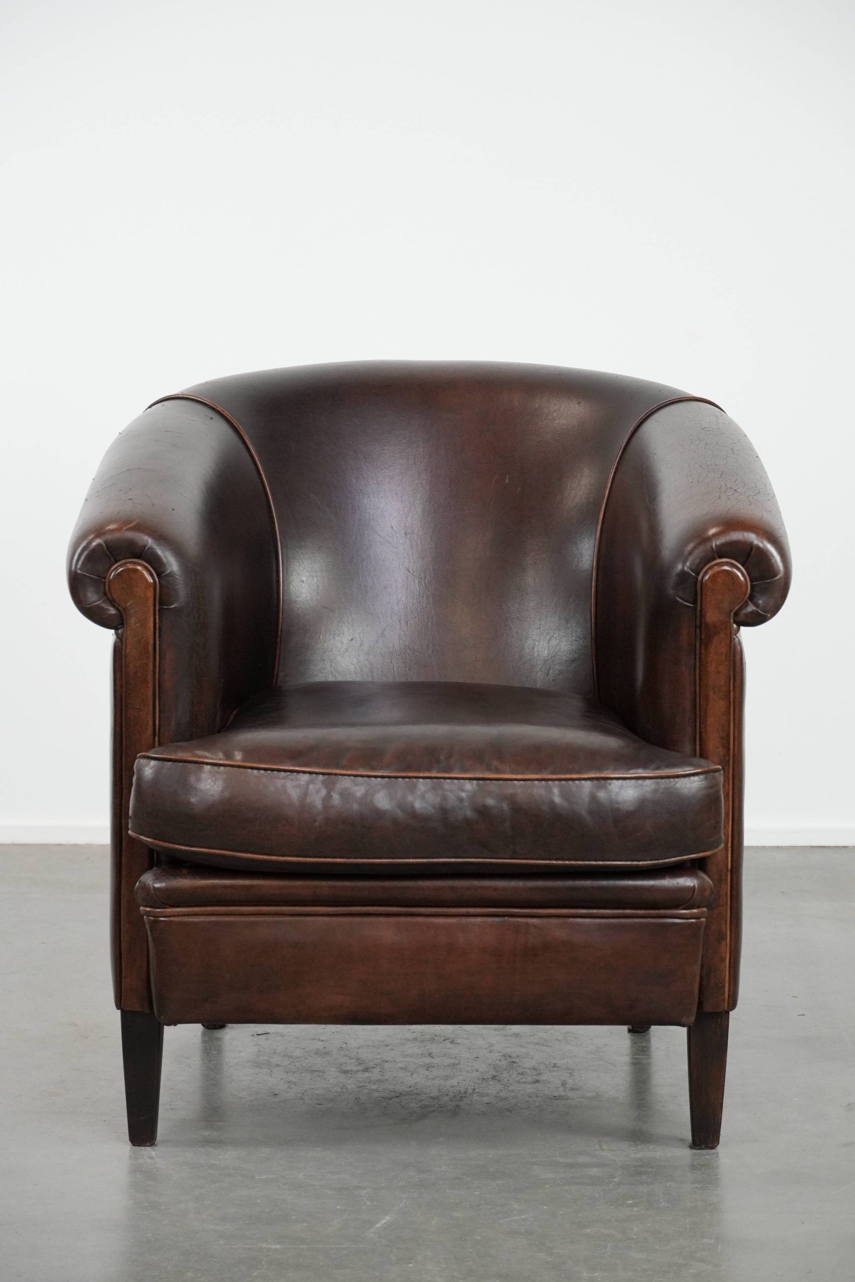 Dark brown vintage club armchair in English style made of sheepskin leather