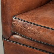 Comfortable sheepskin armchair in unique design finished with black piping