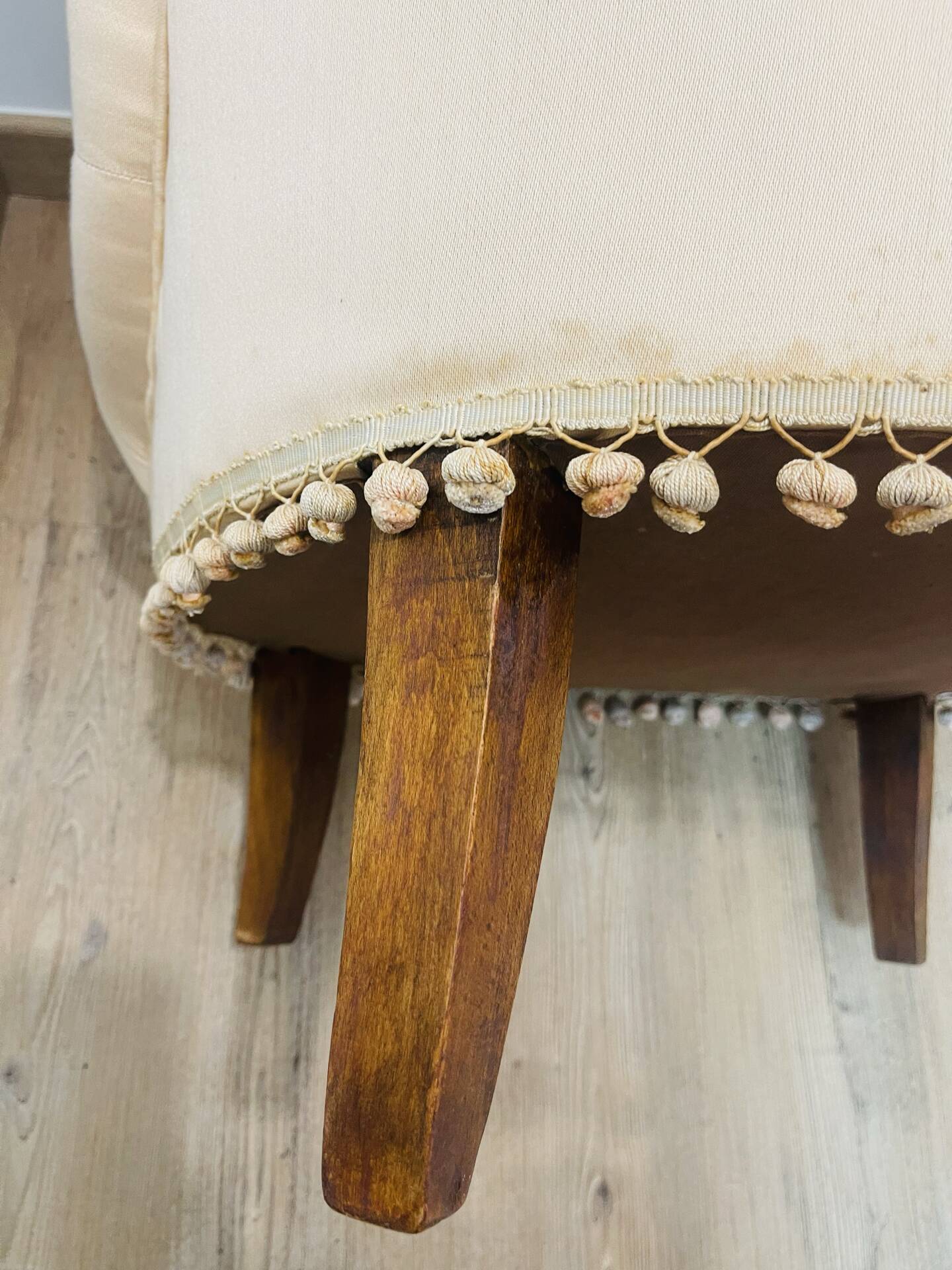 Pale pink upholstered armchair with wooden legs.