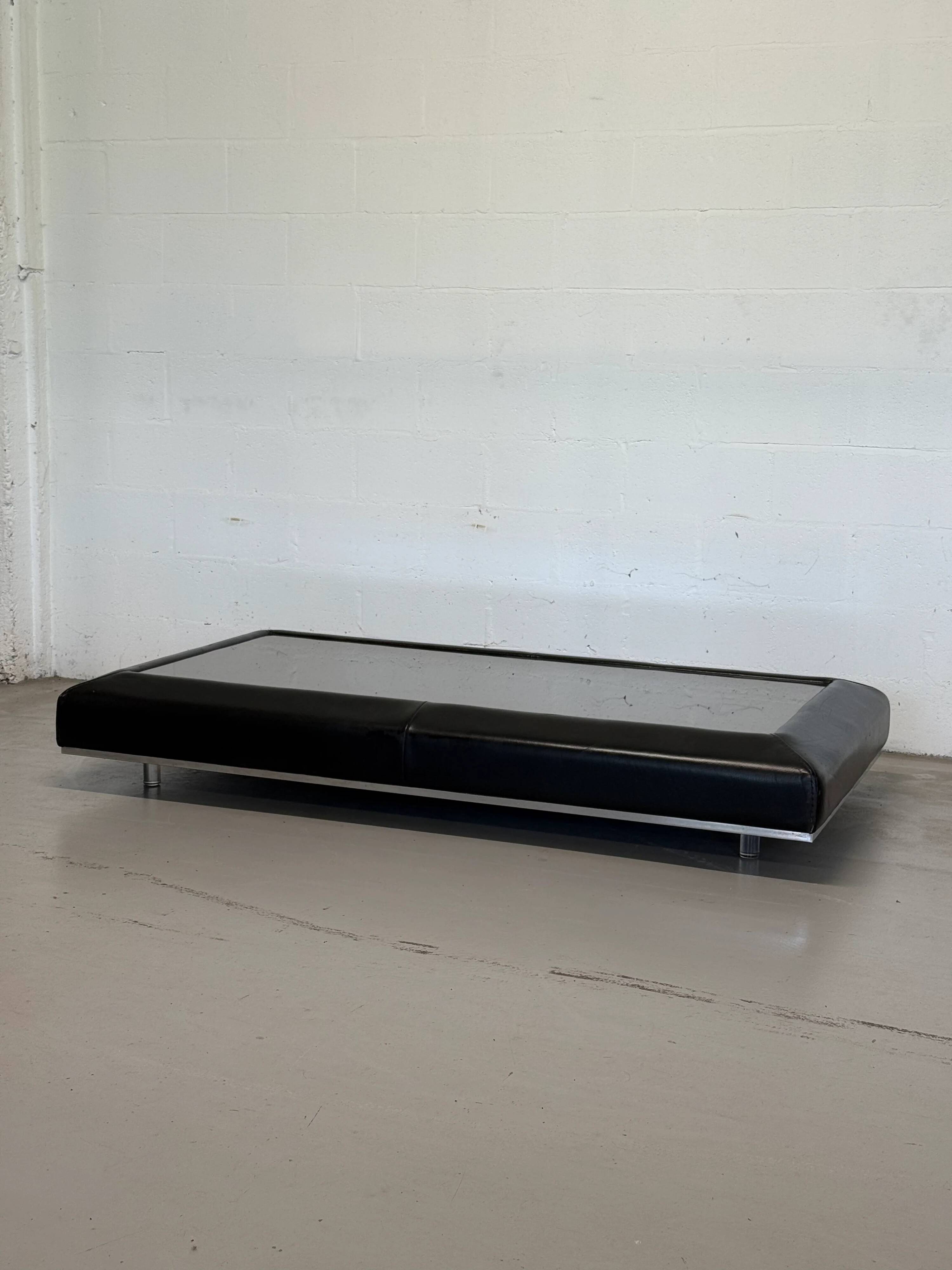 Vintage coffee table covered in leather, smoked mirror top and chrome legs.