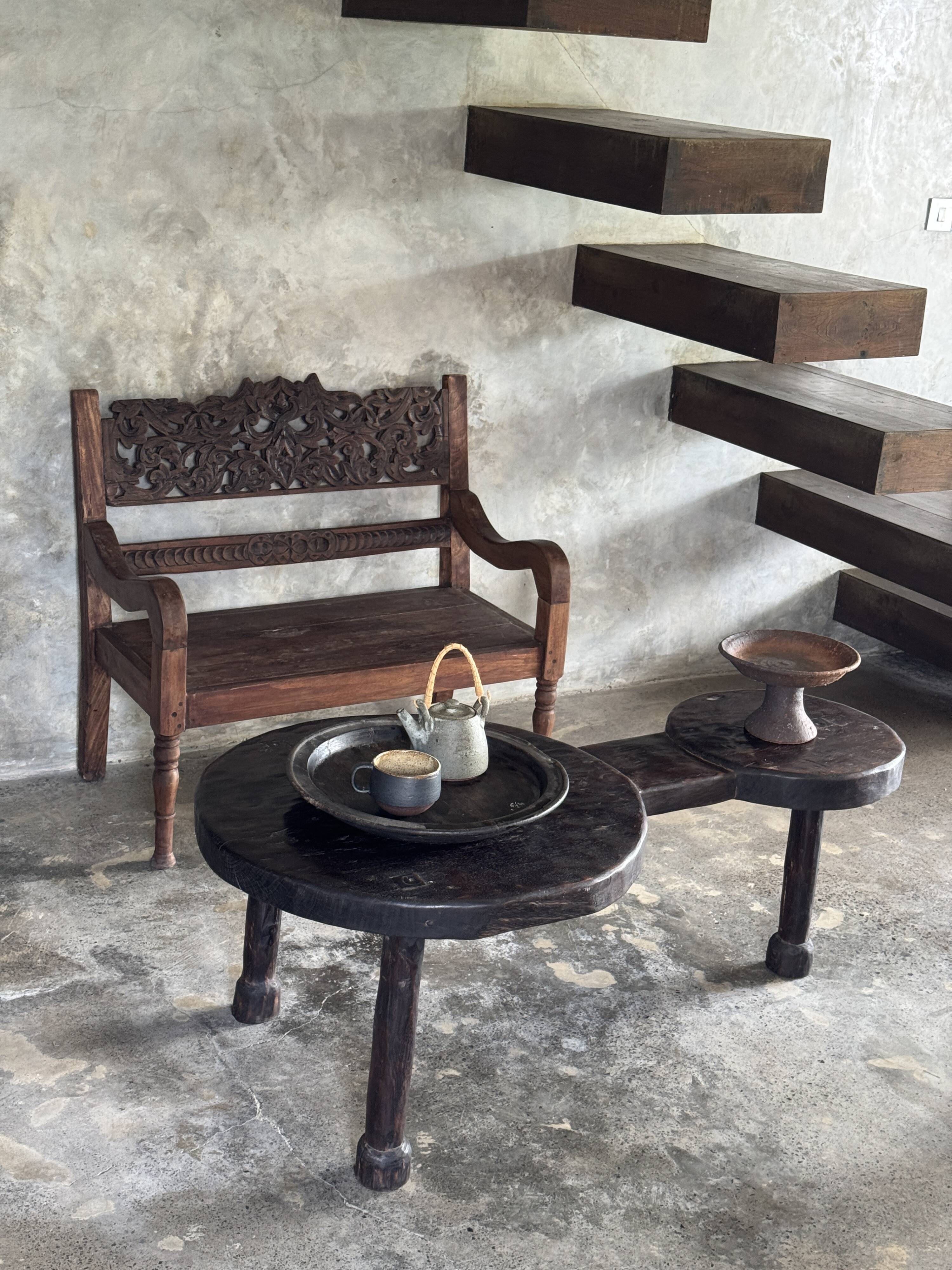 Small antique Indonesian bench in carved teak with plant and floral motifs.