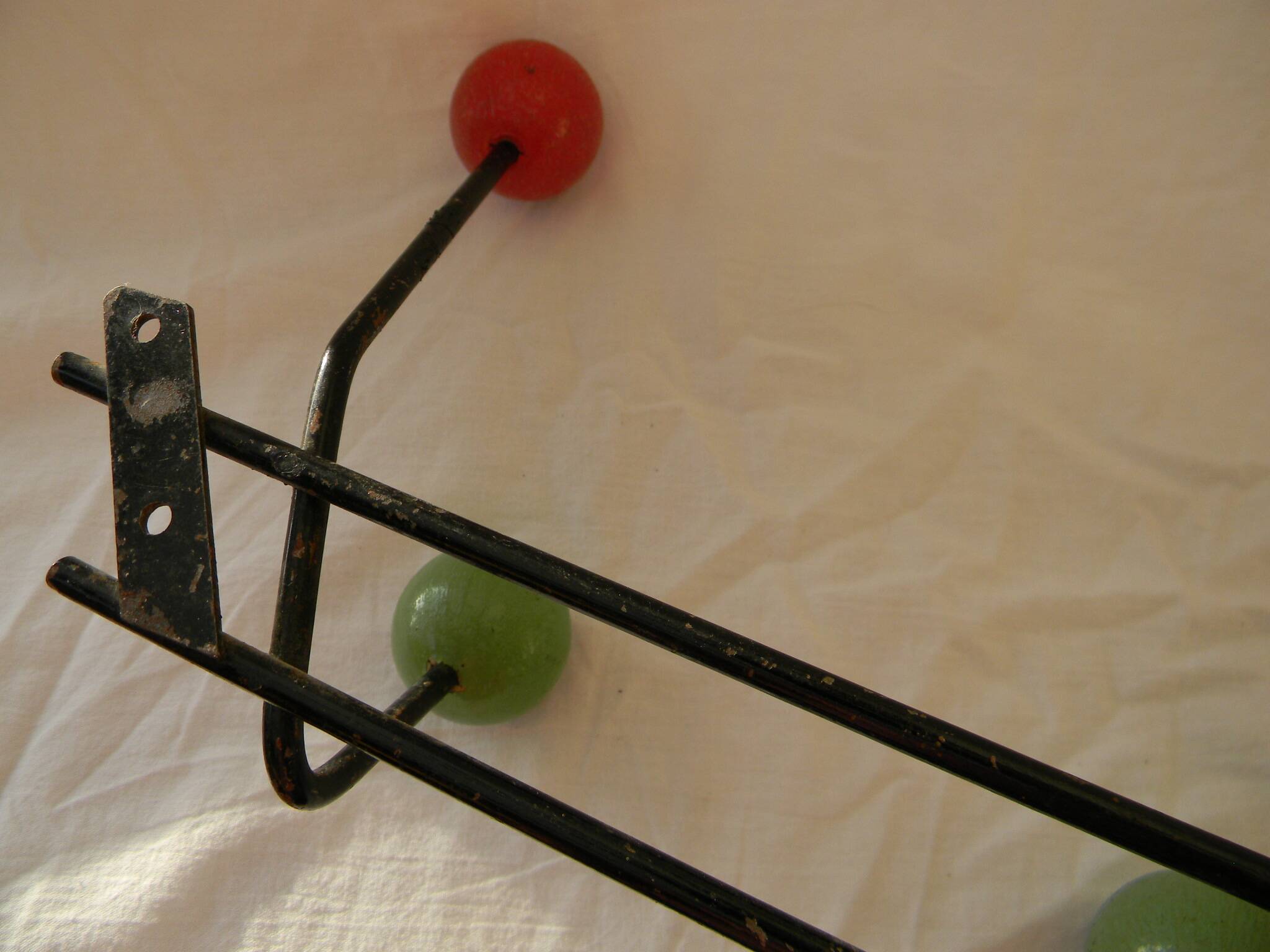 Small wrought iron coat rack with wooden balls.
