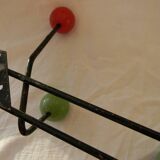 Small wrought iron coat rack with wooden balls.