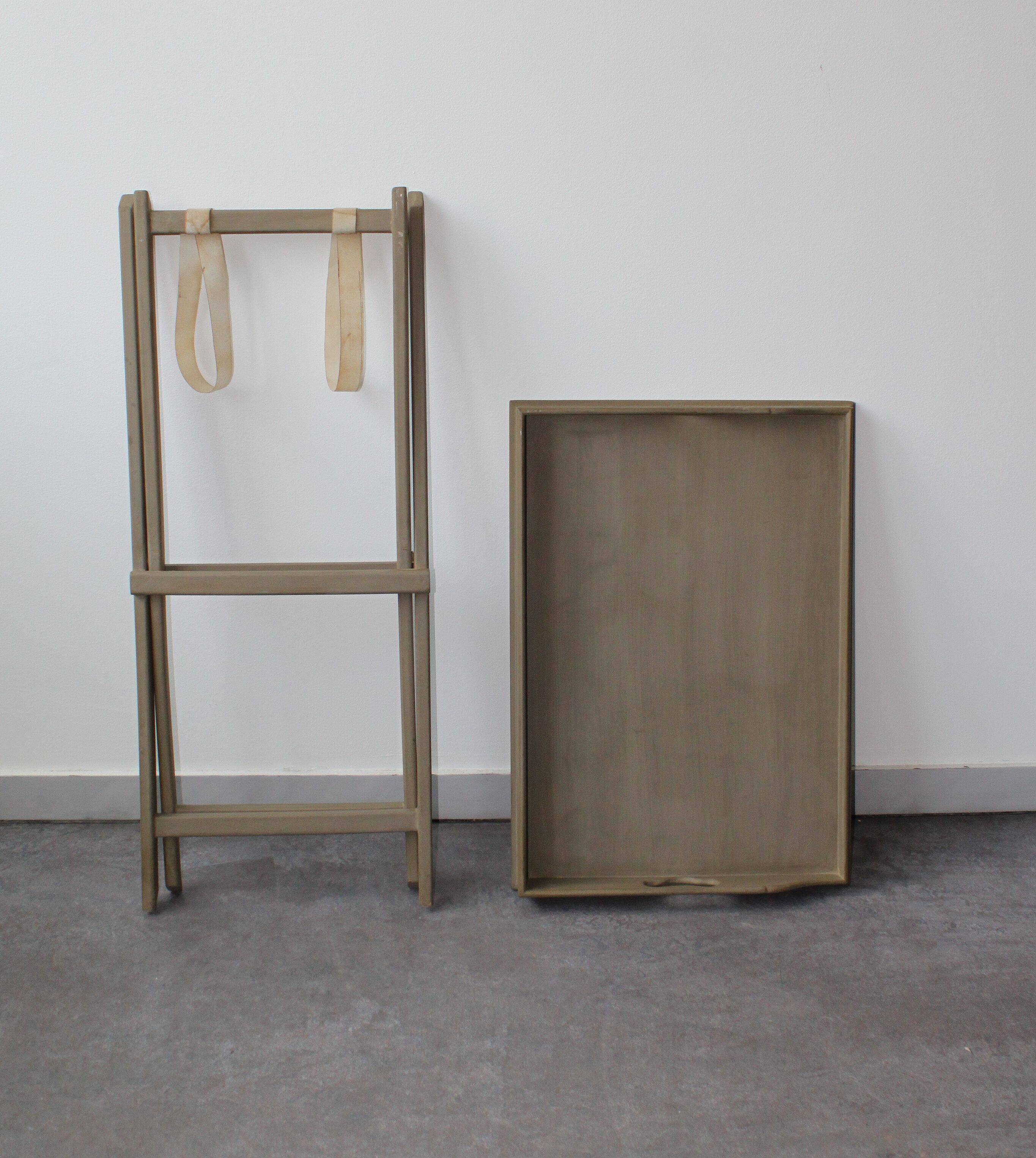 Folding and removable service tray in taupe-painted wood.