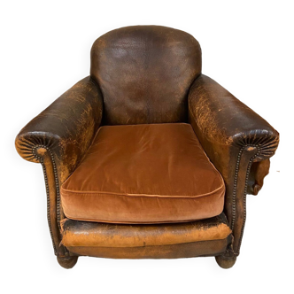 Old club armchair in 1930s style leather round back patinated by time