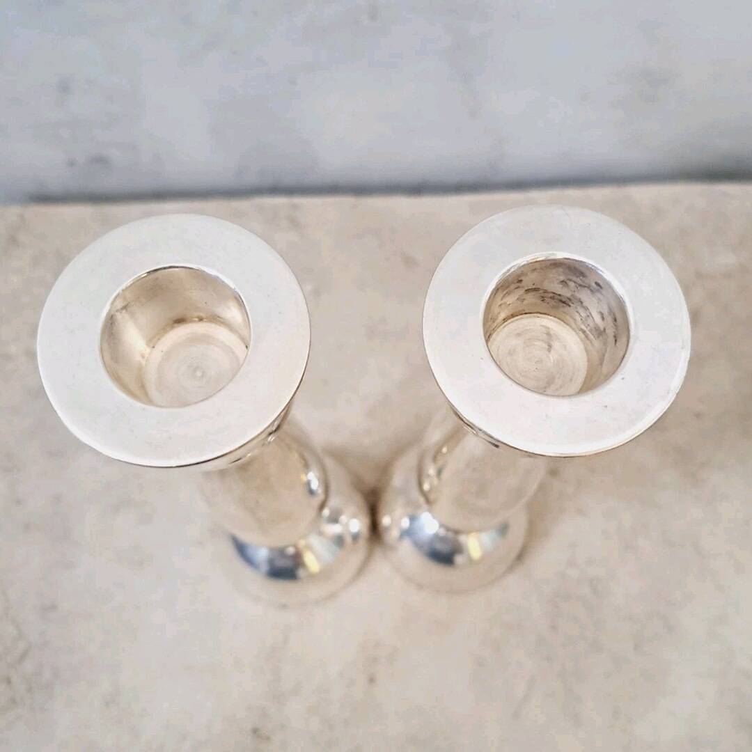 Pair of silver-colored metal candlesticks.