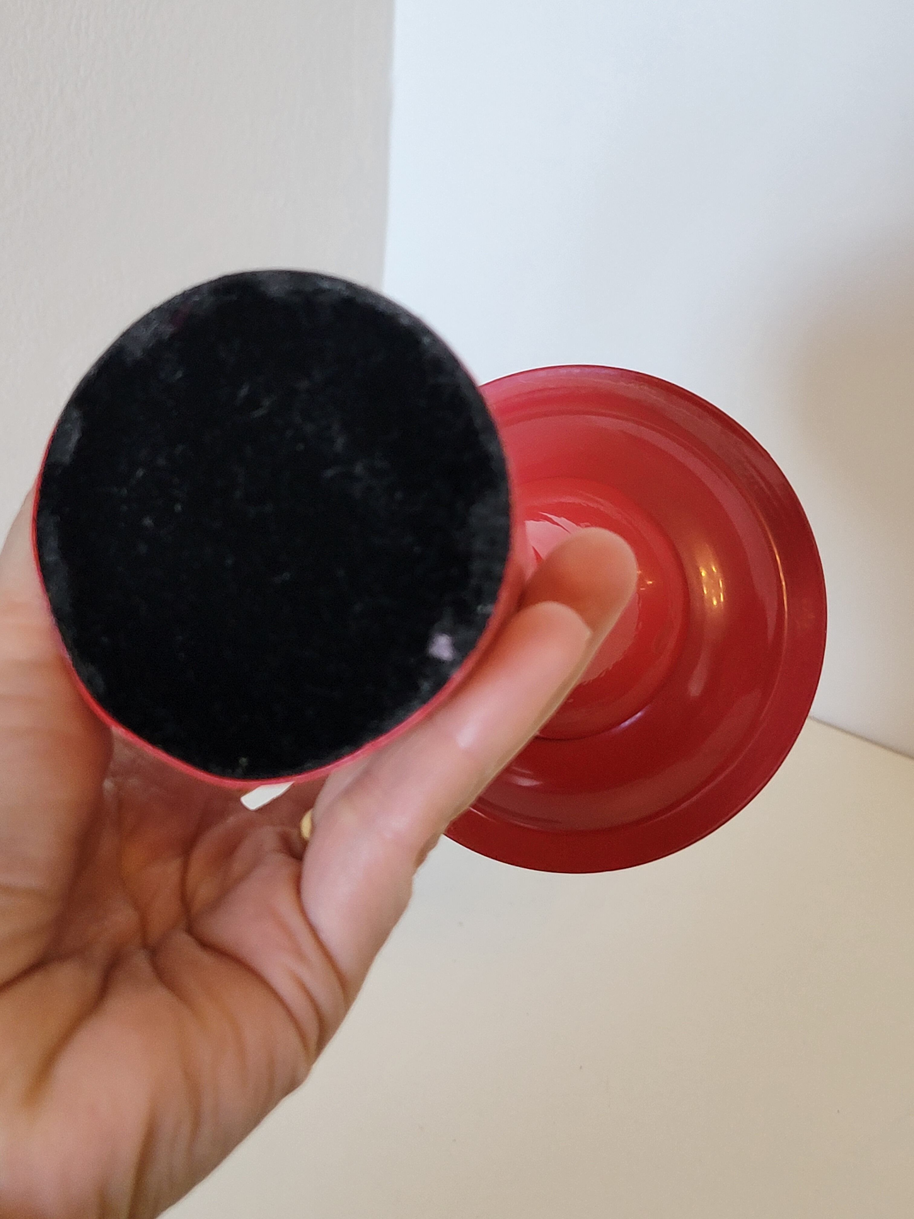 Vintage design candlestick in red metal in the shape of an hourglass