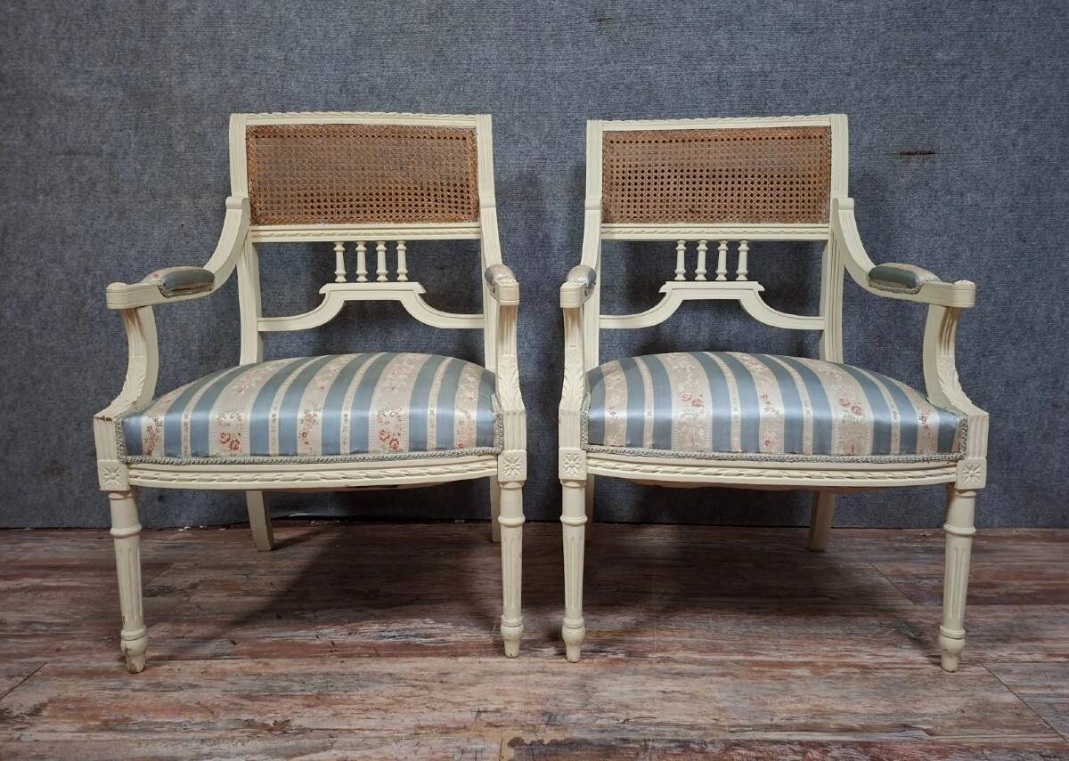 a pair of caned armchairs in the Louis XVI style, elegant and full of charm.