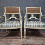 a pair of caned armchairs in the Louis XVI style, elegant and full of charm.