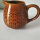 Caramel slipware pitcher with braided relief