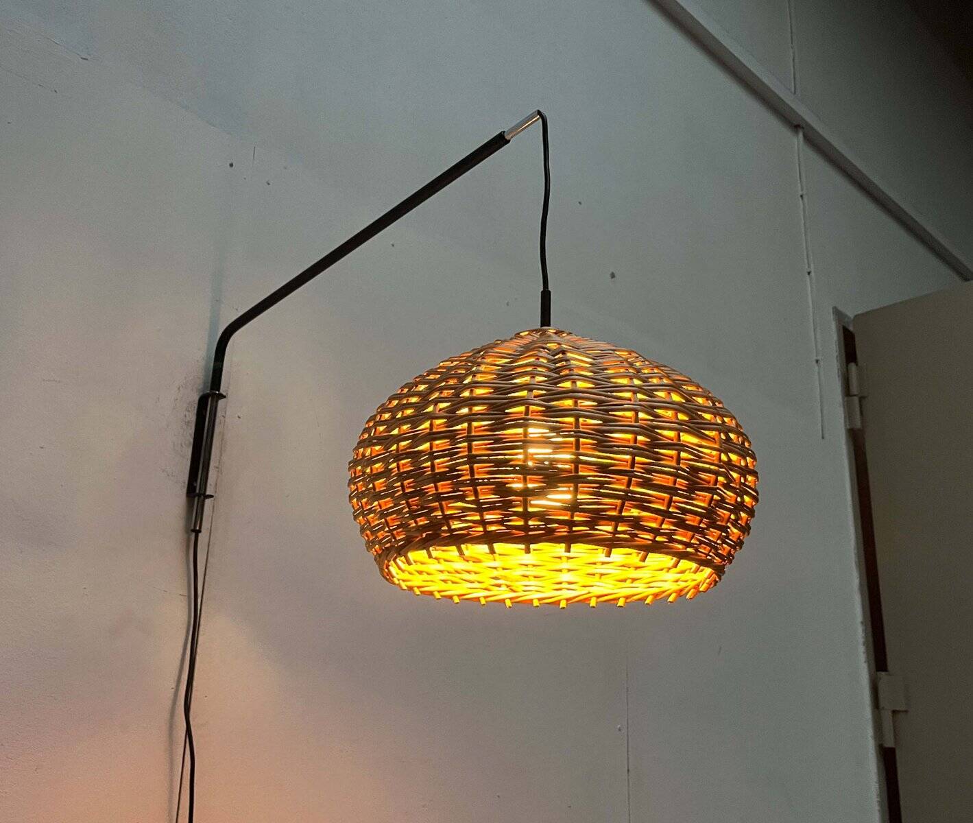 Mid-century modern Danish extendable cantilever wall lamp with a rattan shade, 1960s.
