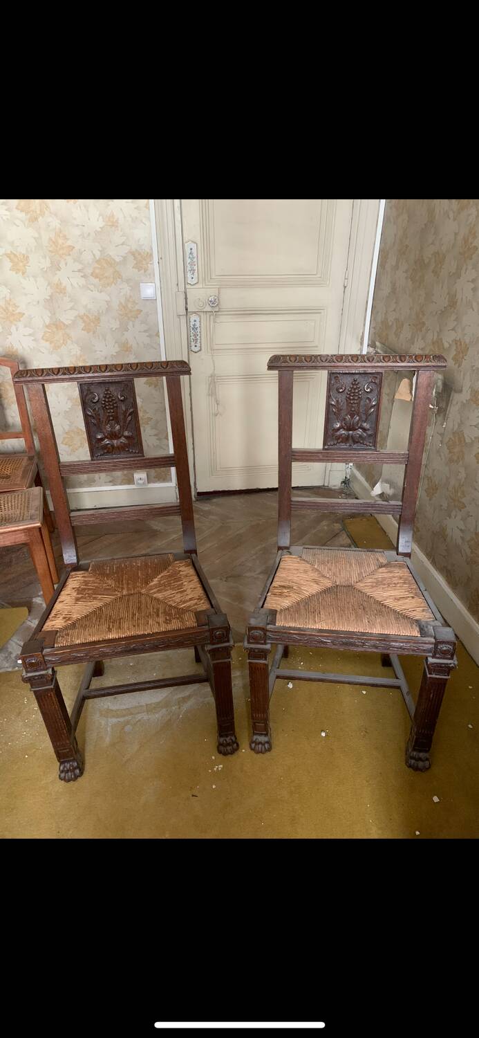 Antique carved wooden chairs with straw seats.