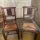 Antique carved wooden chairs with straw seats.