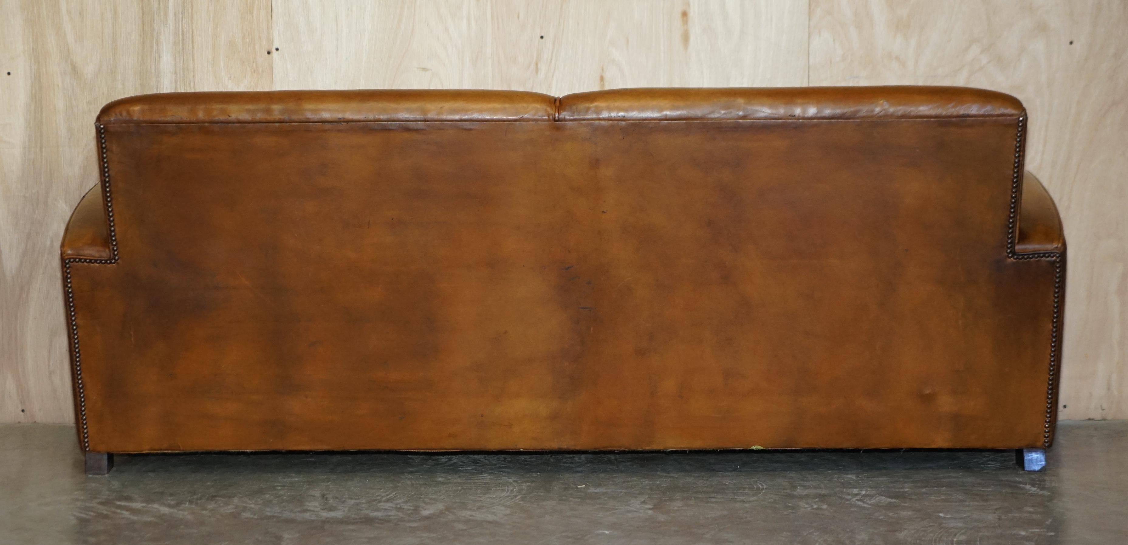Three-seater Art Deco style leather sofa with feather cushions.