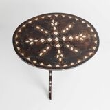 Vintage side table from the early 19th century, dark wood with mother-of-pearl inlays, oval shape with three legs, ethnic style.