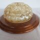 ceiling light with amber glass globe, on a round light wood base