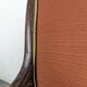 Restoration armchair in mahogany with cross arms and orange fabric.