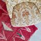 Beige toad armchair with floral patterns and red fringes