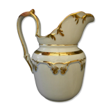 Milk jug or antique pitcher in white and gold porcelain.