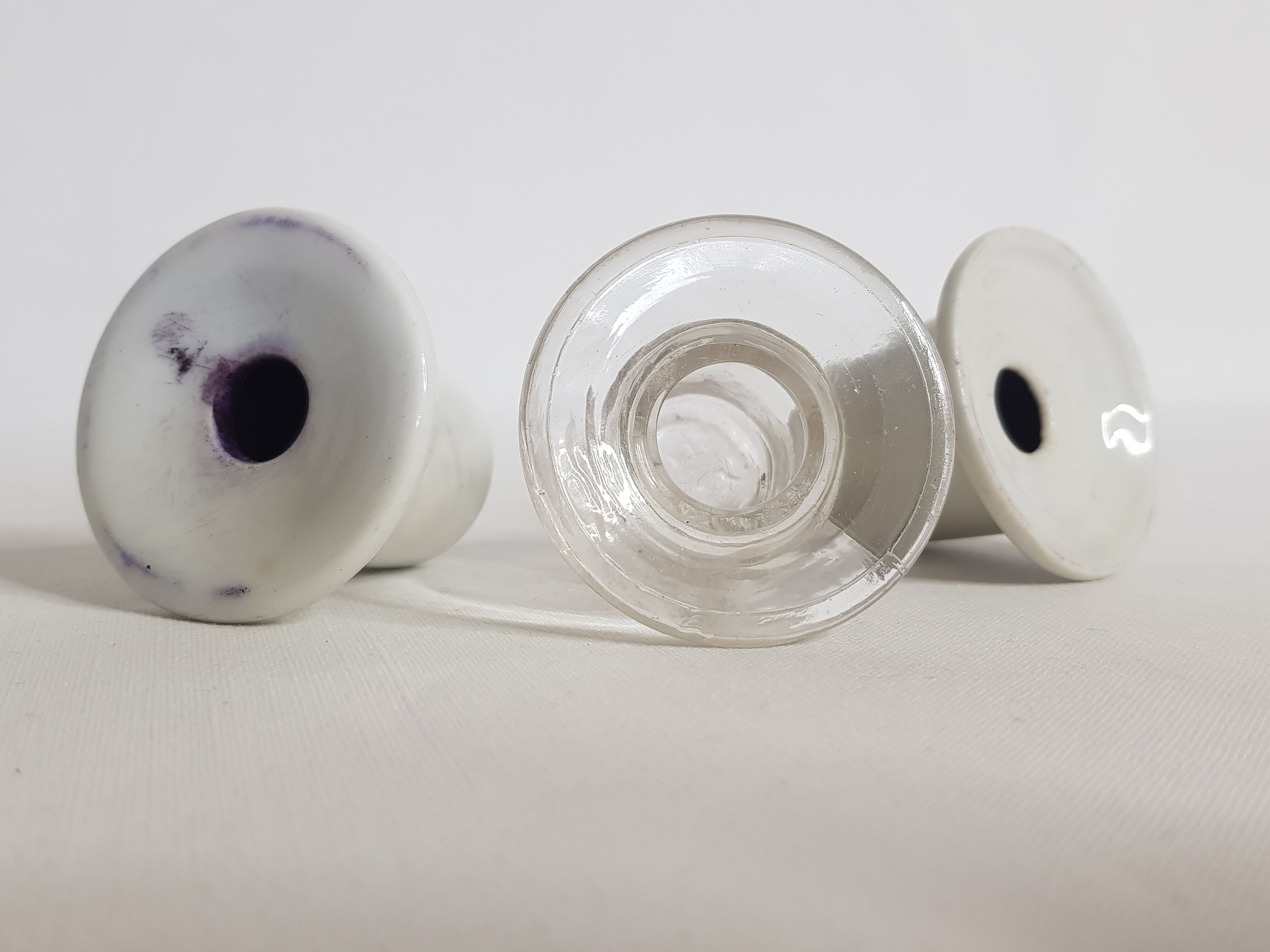 Three white porcelain and glass inkwells for school desk