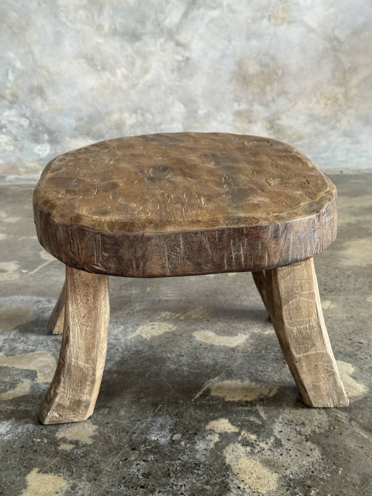 Small stool, oval solid teak side table with curved legs in wabi-sabi style.