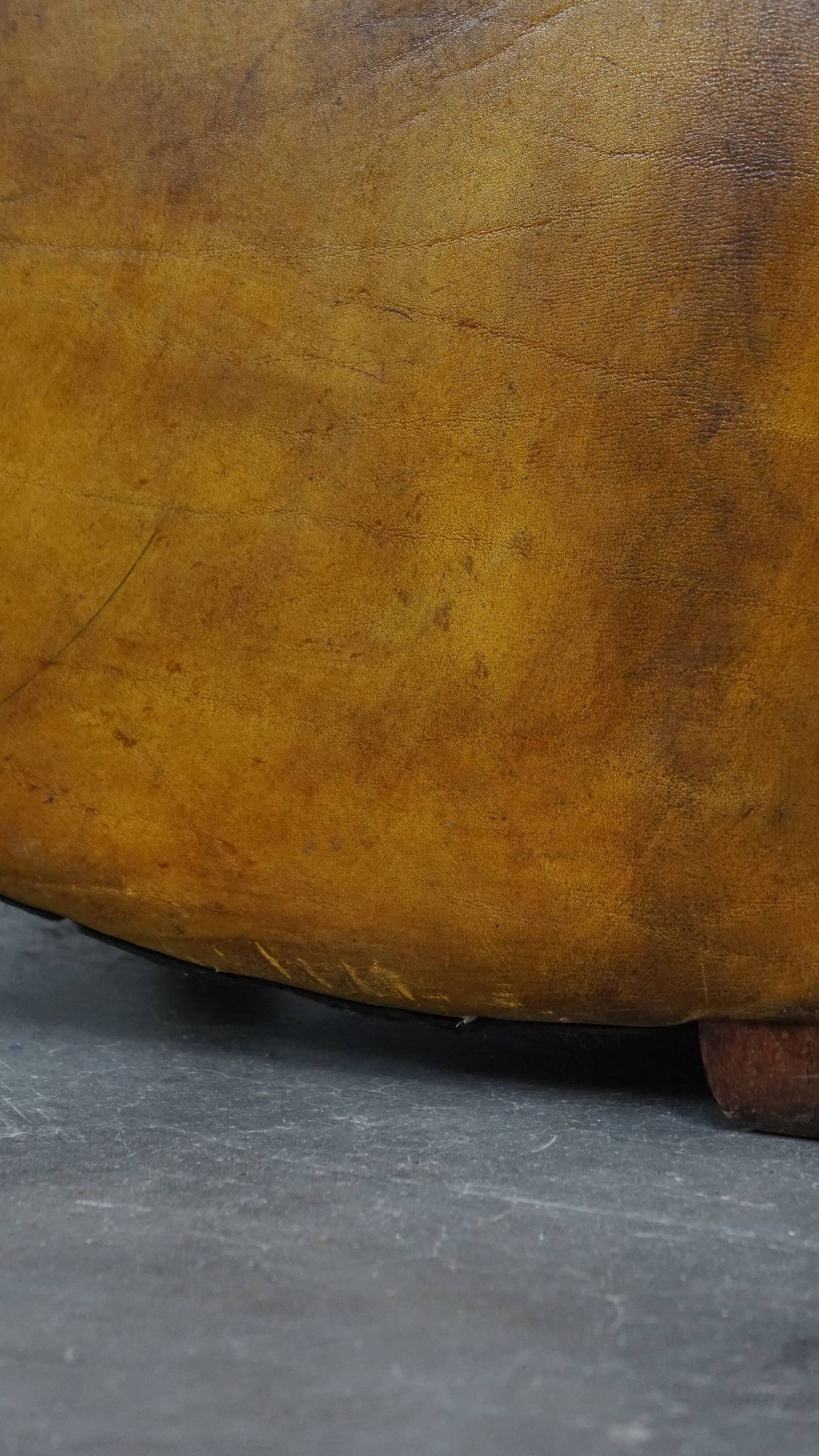 Comfortable large yellow English-style leather armchair with a fine finish and decorative nails
