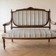 Louis XV style classic canapé reupholstered in striped beige fabric.