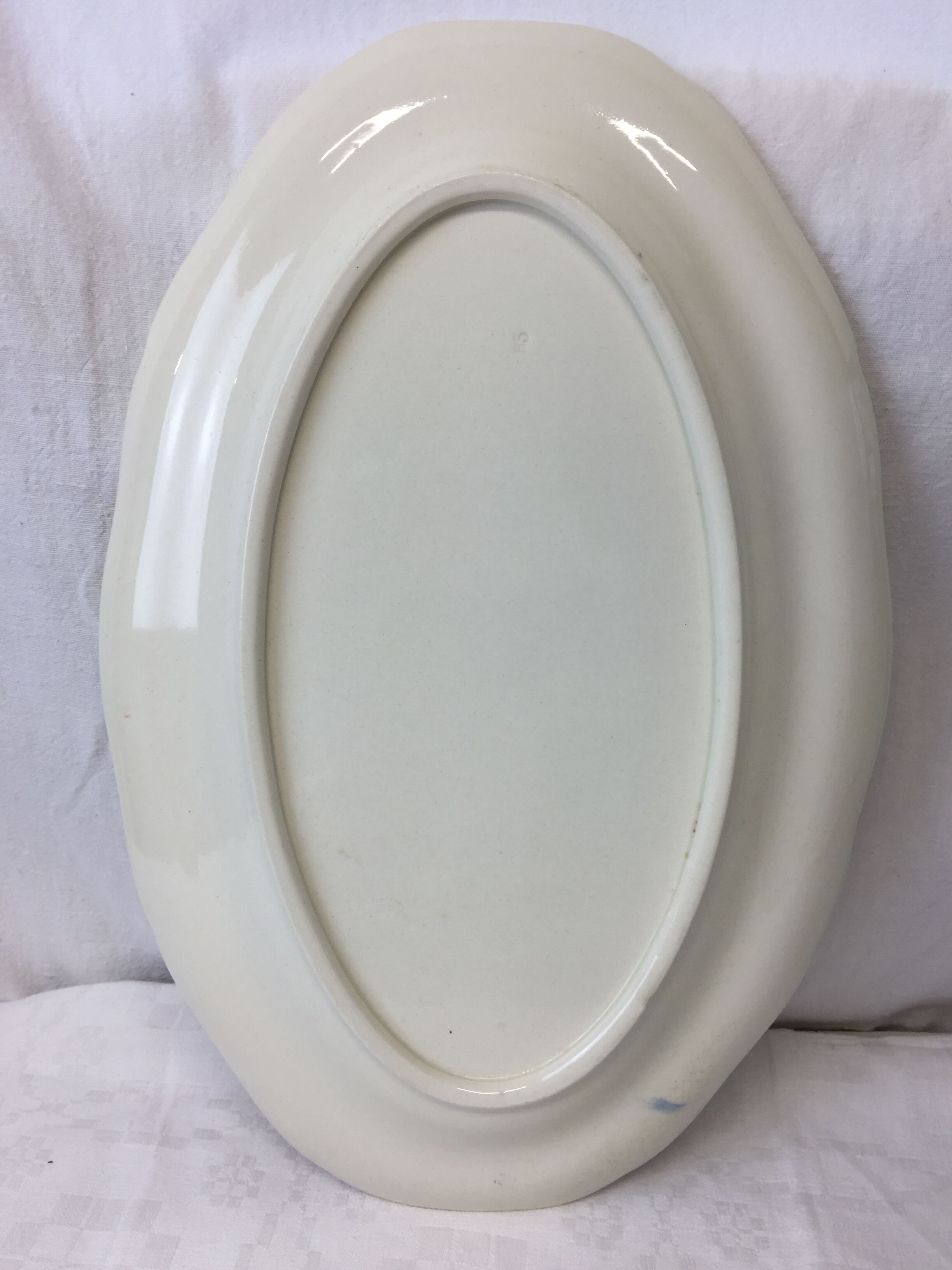 Old ivory-colored, oval-shaped dish with chamfered edge