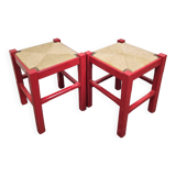 Red wooden stool with woven rush seat.