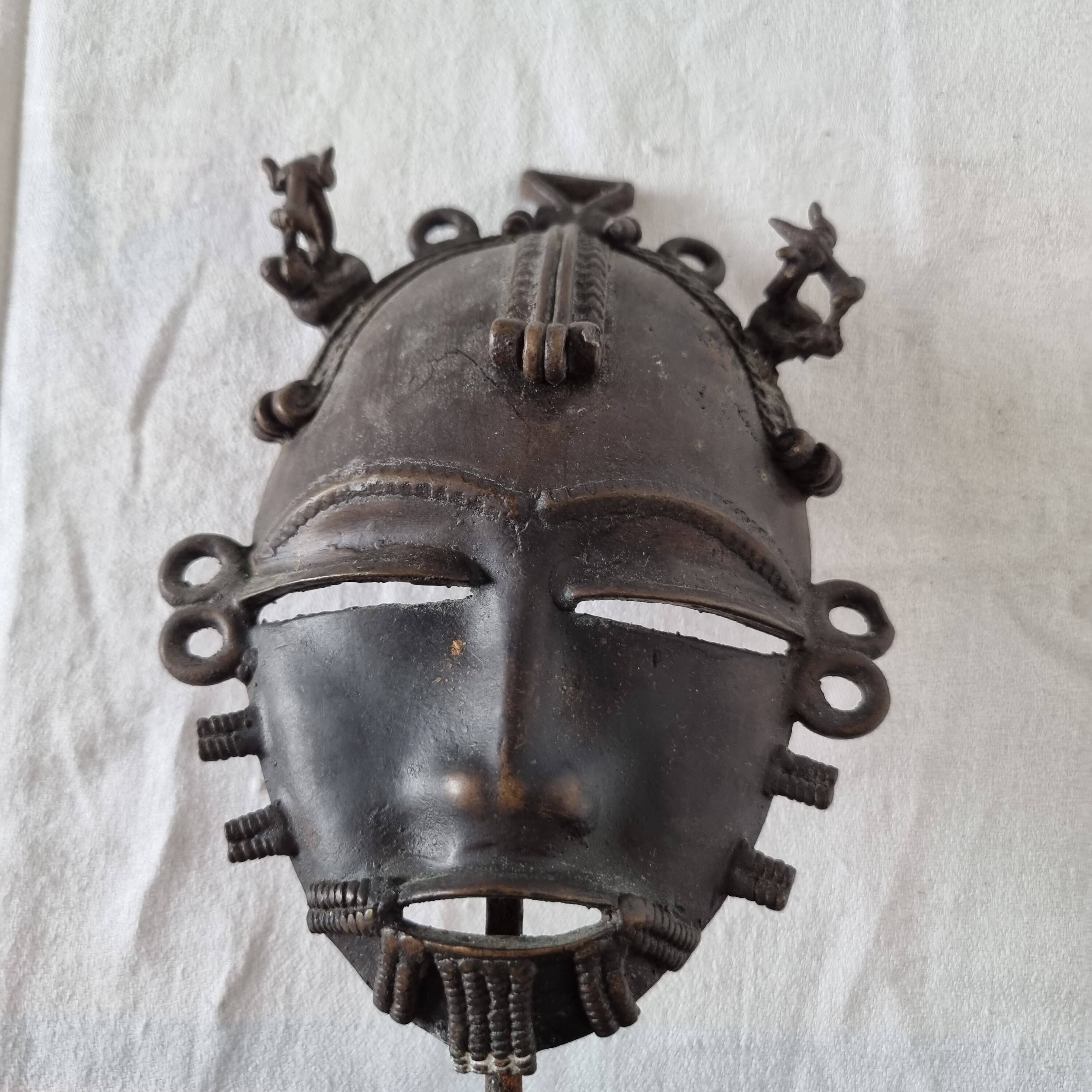 African bronze mask on pedestal, from Ivory Coast, dating