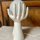 Ceramic table lamp depicting two hands holding a globe, 1980
