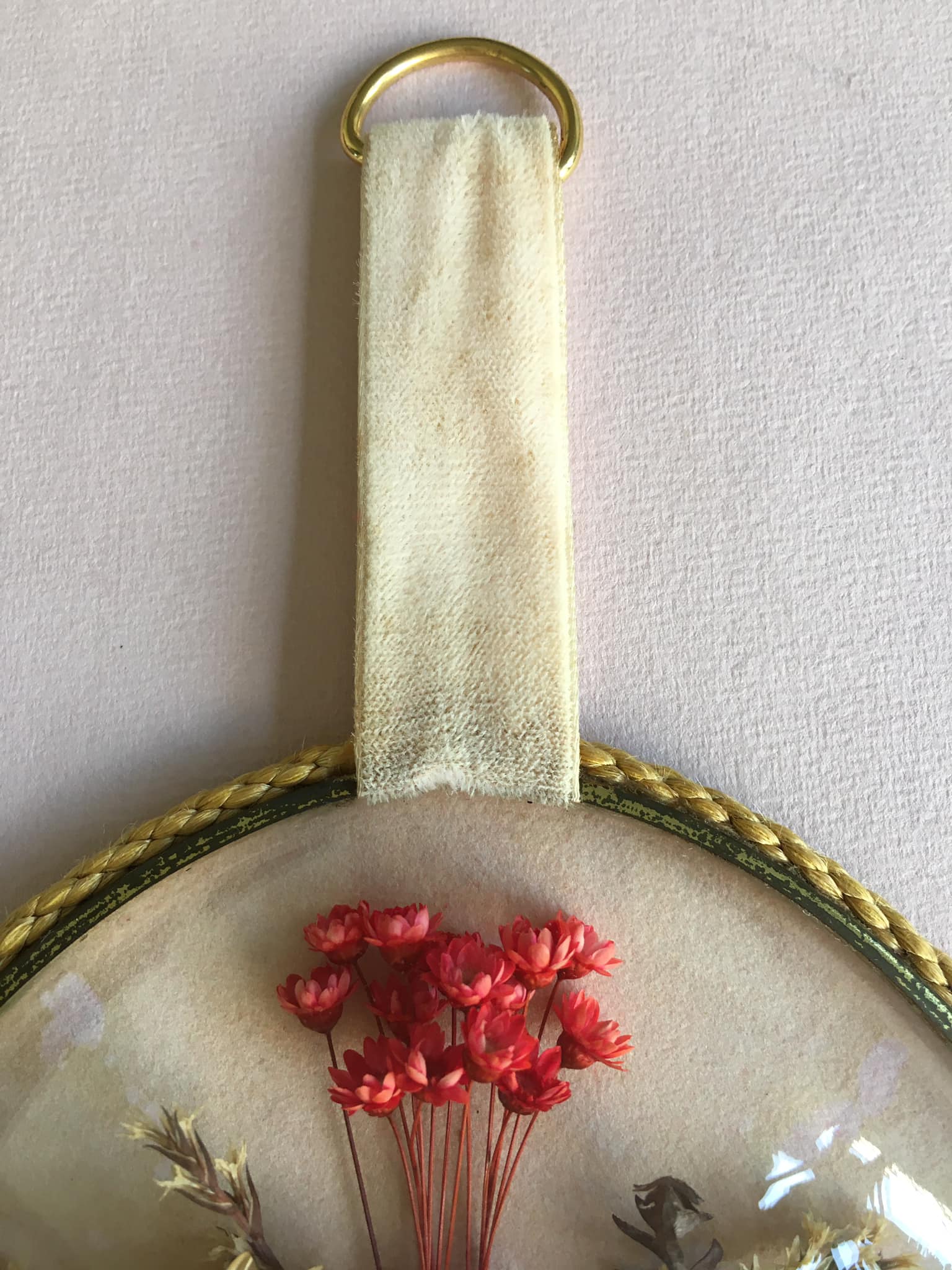 Old medallion frame of dried flowers of oval shape. To hang with velvet stripe.