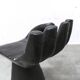 Black armchair chair in carved wood in the shape of a hand
