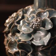Une paire de lampes bleu clair iridescentes, avec un design de buisson floral.
