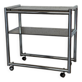 Vintage bar cart in chrome and smoked glass on wheels.