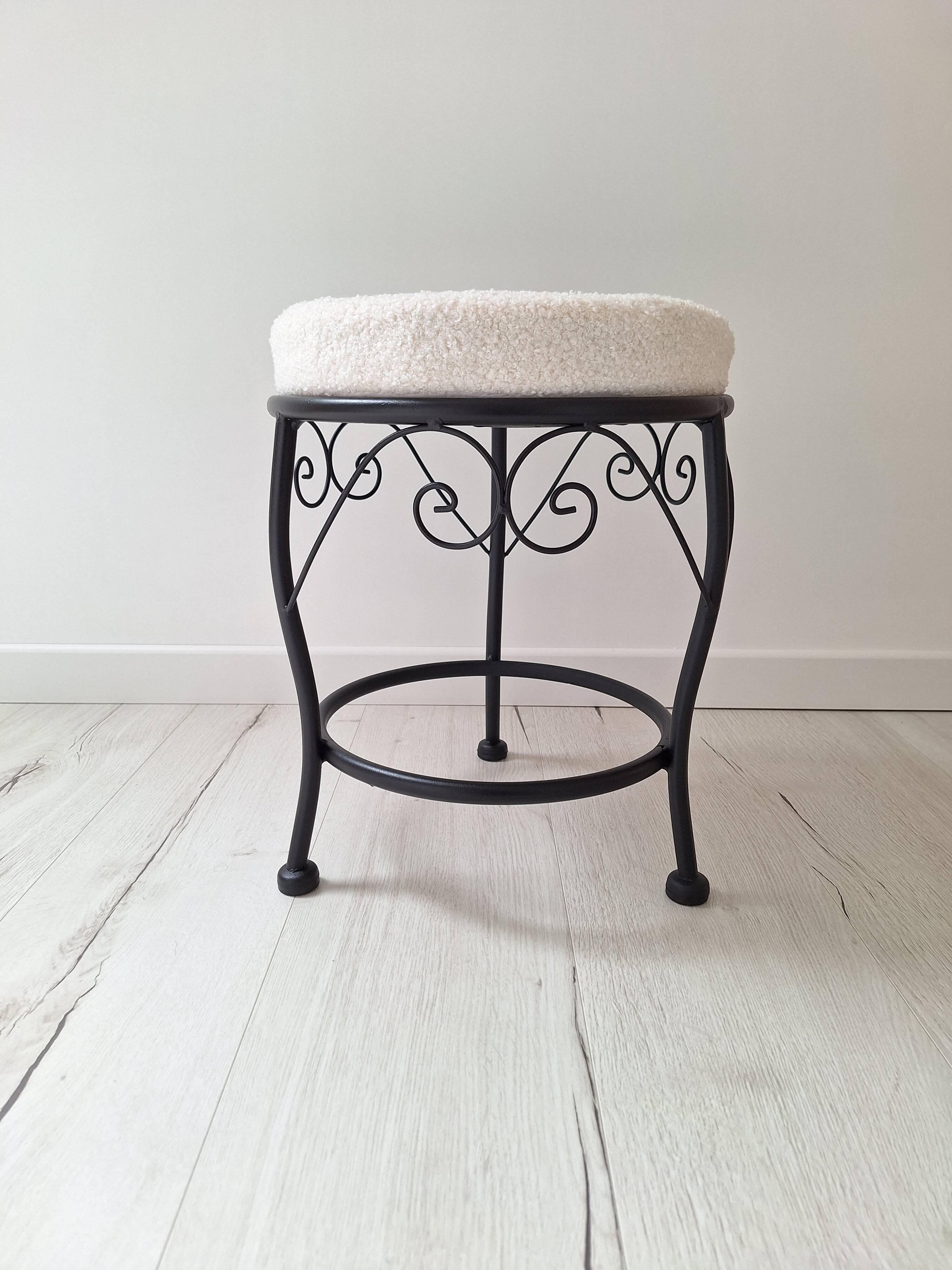Black iron stool/pouf with its boucle fabric cushion.