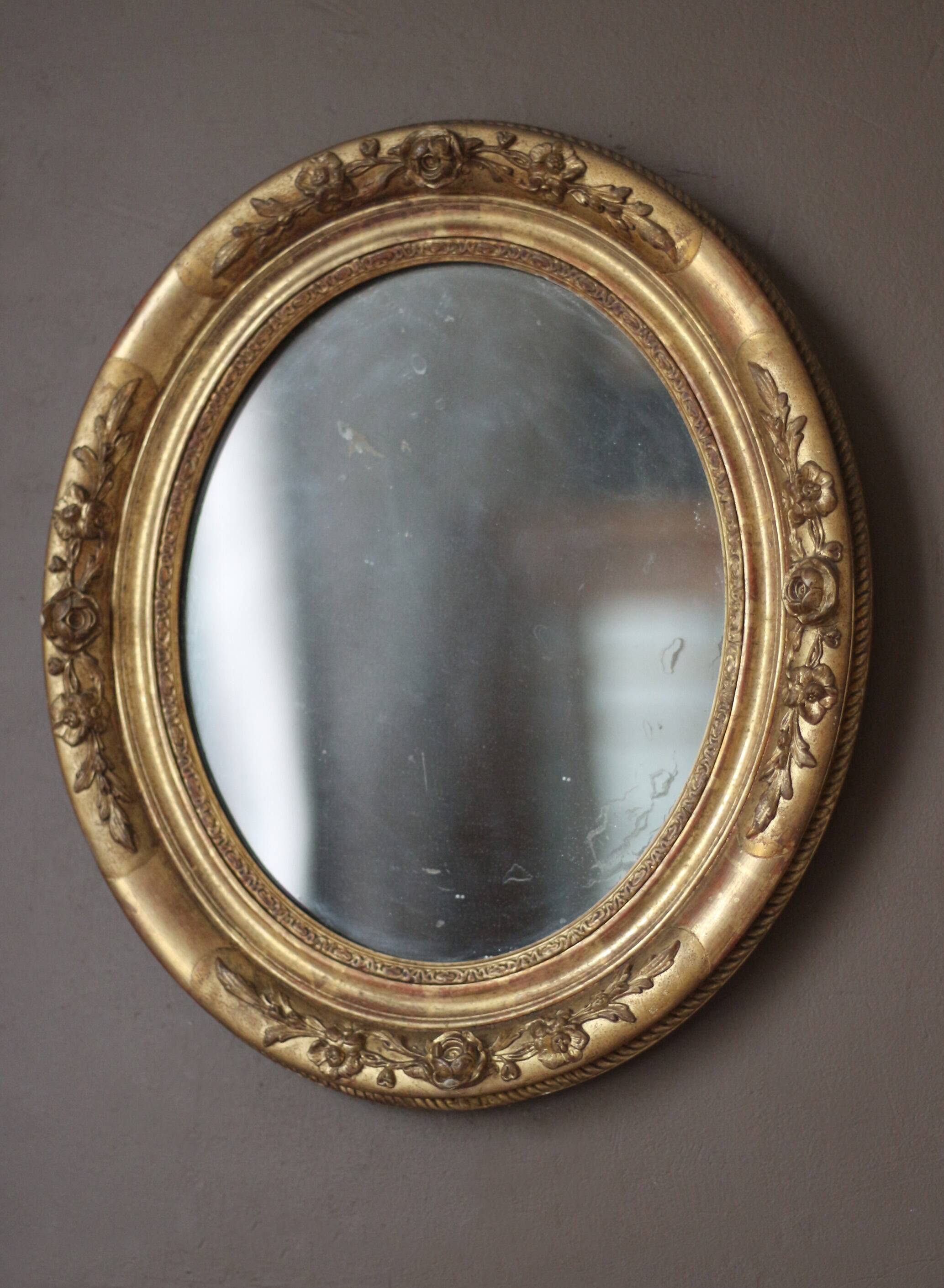 Oval wall mirror with gilded frame and mercury glass. Late 19th-early 20th century.